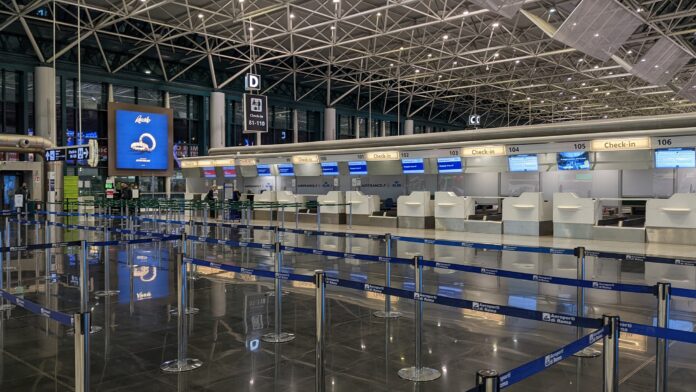 Interno di un aeroporto con banchi del check-in vuoti