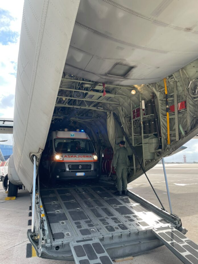 Ambulanza all'interno della rampa di carico di un velivolo C-130J dell'Aeronautica Militare.