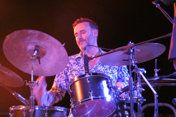 Persone sedute ad assistere a un concerto jazz all'aperto di sera a Procida.