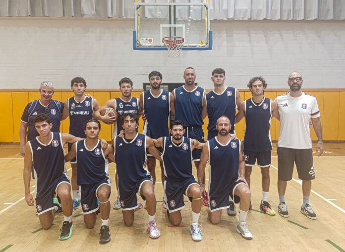 Foto illustrativa della squadra Pirossigeno Cosenza Basket in posa in palestra con divise da gioco in una foto di gruppo.