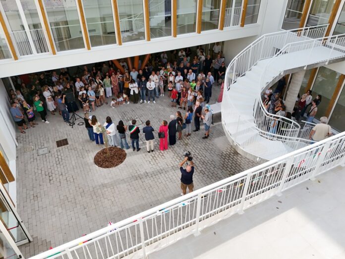 Veduta interna della nuova scuola Anna Frank a Santa Maria delle Fabbrecce durante l'inaugurazione con la presenza di alunni, famiglie e personale scolastico.