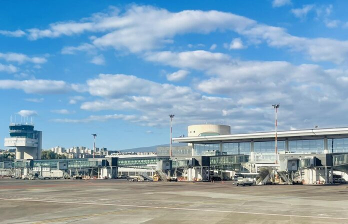 Terminal e pista dell'aeroporto di Catania Lotto, vuoti e con cielo sereno.