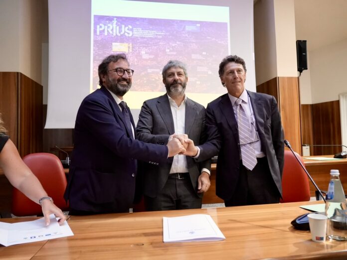 Cerimonia di sottoscrizione dell'accordo di programma Regione Campania per rigenerazione urbana ad Avellino, con uomini seduti a un tavolo e proiezione sullo sfondo.