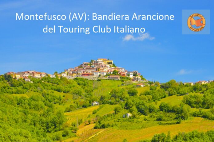Veduta panoramica del borgo di Montefusco in Campania con campi verdi e cielo sereno.