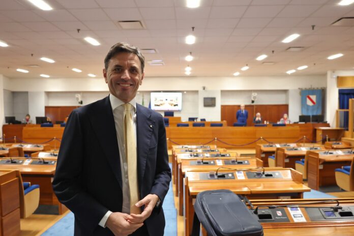 Consigliere regionale in aula parlamentare seduto tra i banchi istituzionali.