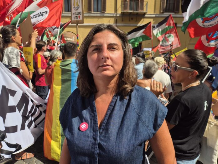 Francesca Druetti in piazza durante manifestazione contro DDL Antisemitismo con bandiere e persone sullo sfondo