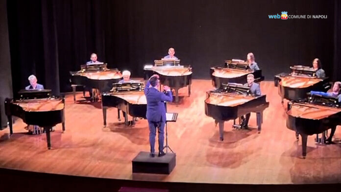 Concerto di pianoforte con più musicisti e direttore d'orchestra sul palco durante il festival Piano City Napoli
