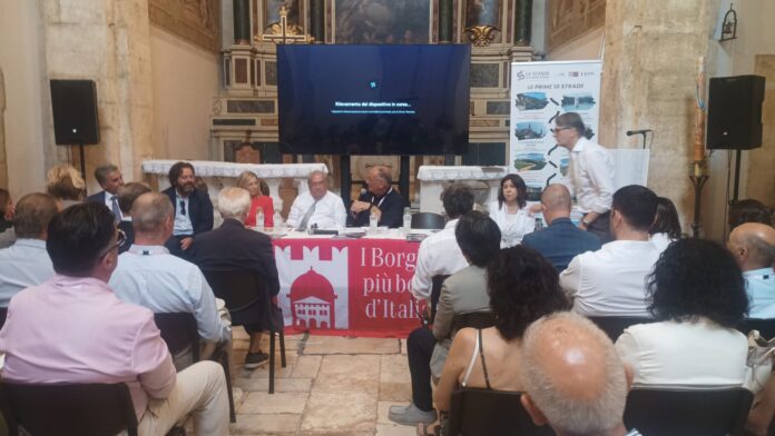 Gazebo del festival nazionale dei Borghi più Belli d'Italia con esposizione di prodotti tipici della Calabria e persone presenti.