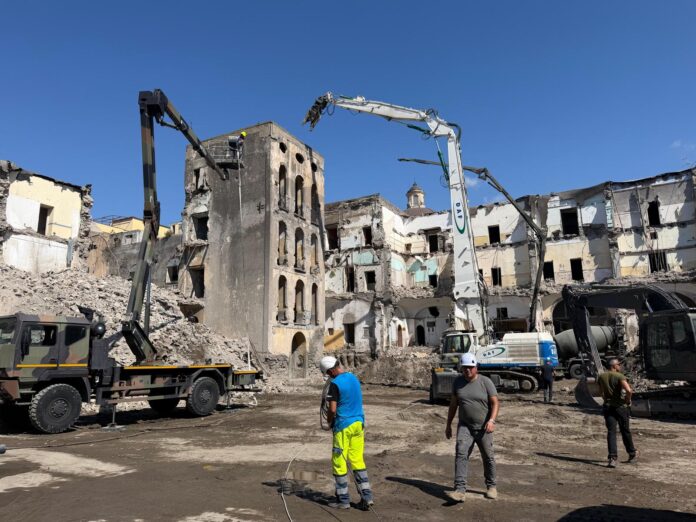 Torre di Palazzo Fienga in fase di demolizione con mezzi e operai al lavoro a Torre Annunziata