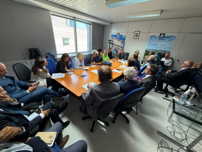 Partecipanti riuniti attorno a un tavolo in una sala riunioni per l'insediamento dell'Osservatorio regionale sul turismo in Campania.