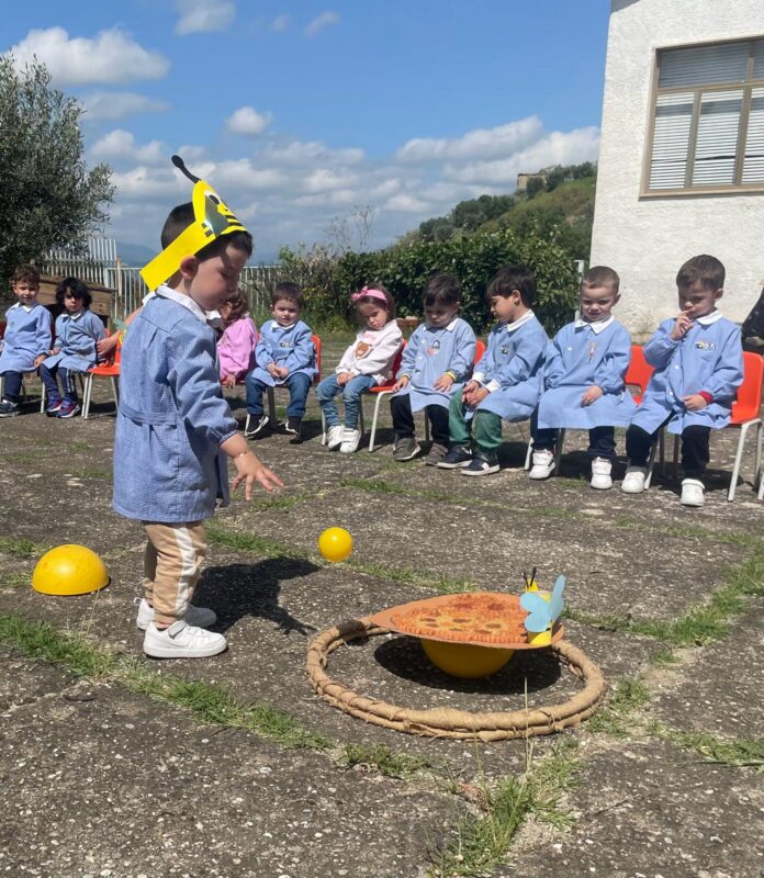 Gruppo di bambini e adulti in ambiente scolastico durante attività educativa della cooperativa Maya a Bisignano