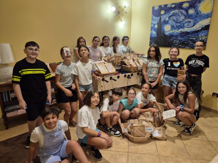 Giovani in un negozio con pane e materiale relativo all'iniziativa culturale 'Pane e Poesia', foto di gruppo con sorrisi.