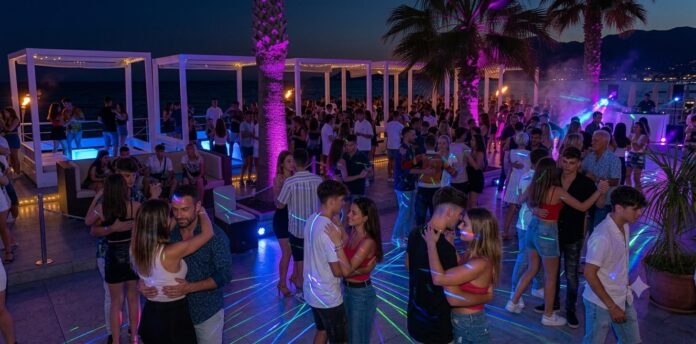 Serata al Sea Garden di Salerno con persone che ballano e socializzano sotto un cielo serale, tra palme e luci colorate.