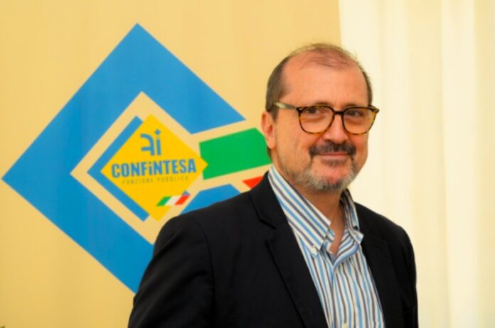Francesco Prudenzano posizionato davanti a un logo Confintesa durante un'intervista