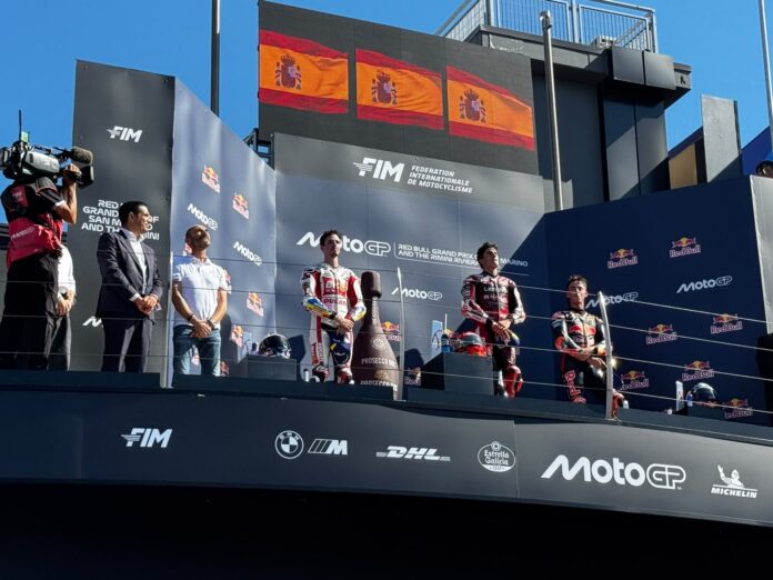 Premiazione al Gran Premio MotoGP di Misano con piloti sul podio e bandiere spagnole.