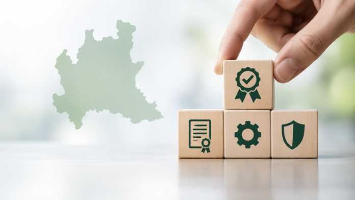 Mano che posiziona un blocco di legno con icona di certificazione accanto a una mappa della Lombardia.