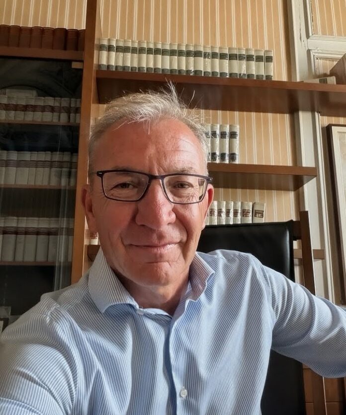 Il sindaco Andrea Pellicini in un ritratto in interni, con mensole di libri sullo sfondo.