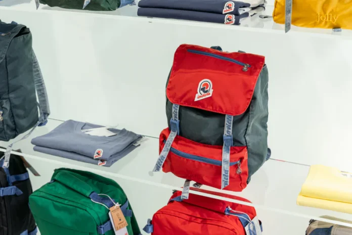Interno del temporary store Invicta a Milano con esposizione di zaini colorati e abbigliamento.