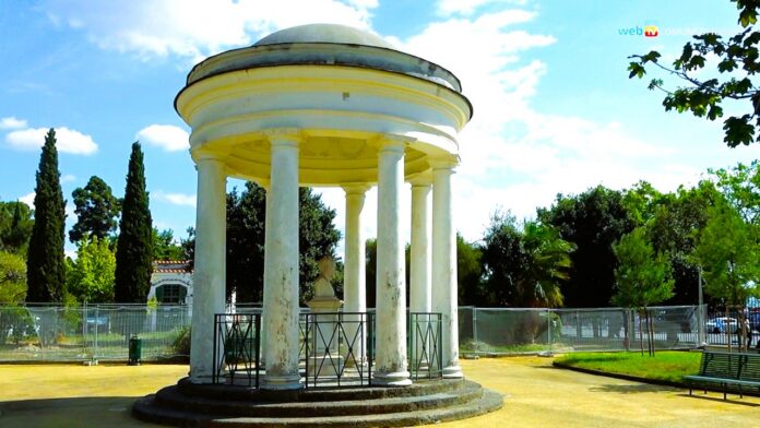 Veduta di una struttura circolare con colonne nella Villa Comunale di Napoli, con area recintata per lavori.