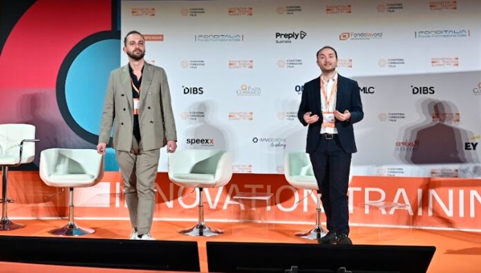 Due relatori su un palco durante un convegno su innovazione e trasformazione digitale nel lavoro e formazione.