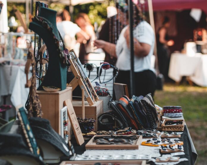 Banchetto artigianale con vari bijoux e oggetti esposti all'aperto in un mercato.