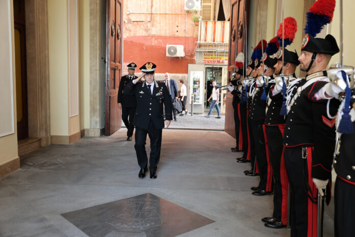 Militari dell'Arma dei Carabinieri schierati a saluto in un cortile interno, durante una cerimonia ufficiale.