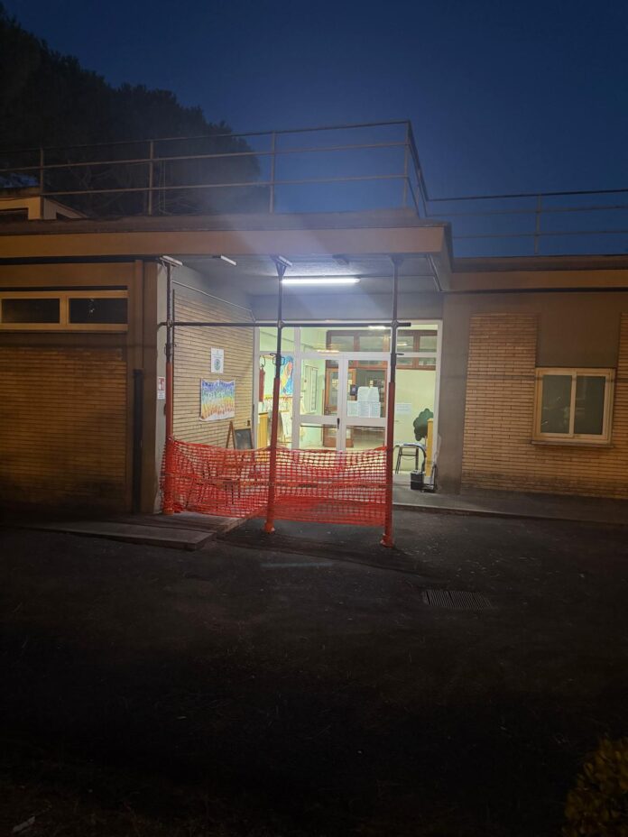 Ingresso scuola nel Municipio V di Roma con lavori di manutenzione e transennamenti visibili di sera