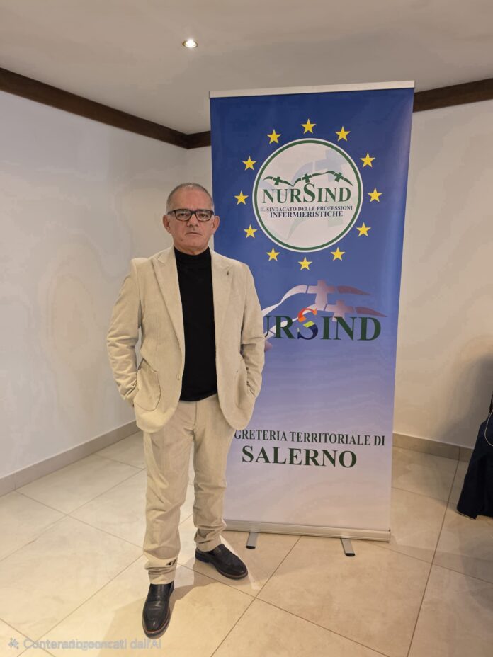 Biagio Tomasco in piedi davanti a uno striscione del Nursind Salerno