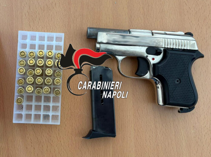 Pistola e proiettili sequestrati dai Carabinieri, posati su un tavolo di legno, con logo Carabinieri Napoli.