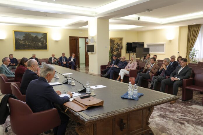 Sala riunioni con persone sedute attorno a un tavolo.