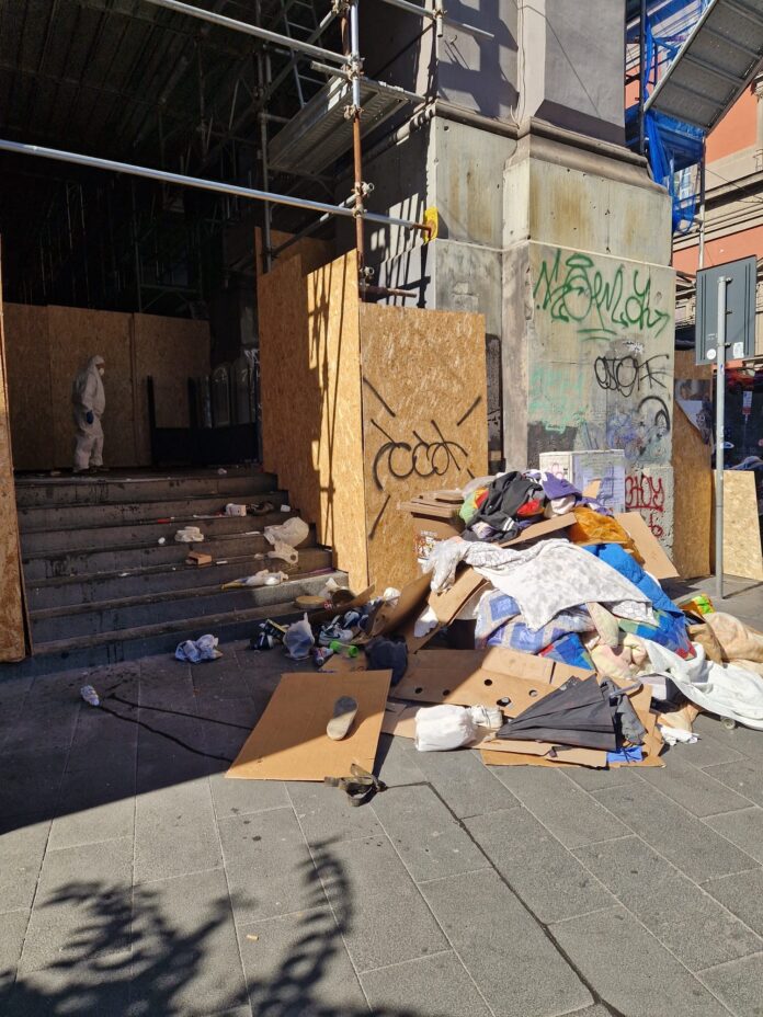 Porticato della Galleria Principe di Napoli con rifiuti ammassati all'ingresso in attesa di essere rimossi durante l'intervento di pulizia e sanificazione.