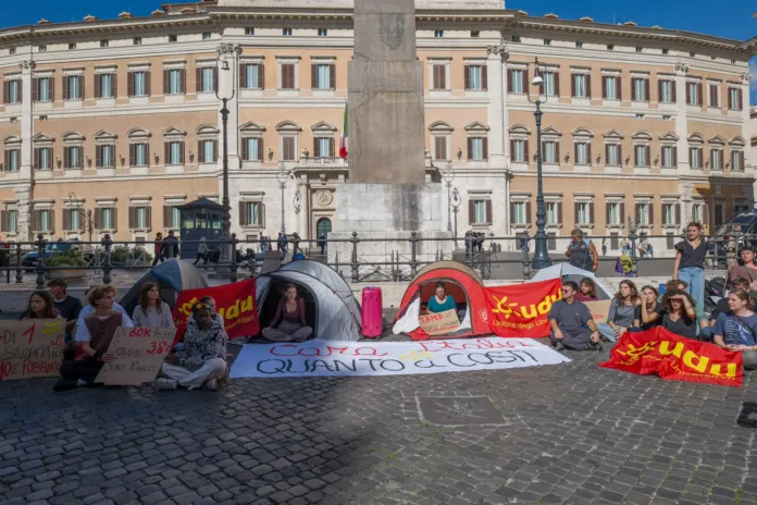 Protesta con studenti e tende in Piazza Montecitorio, Roma, con striscioni dell'Unione degli Universitari.