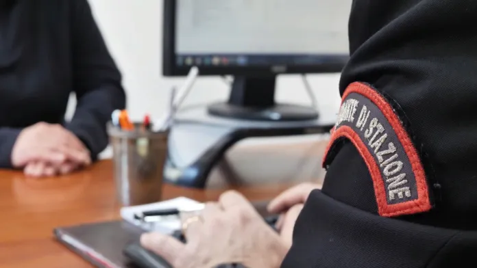 Immagine di archivio di un ufficiale dei carabinieri al lavoro con un computer in ufficio