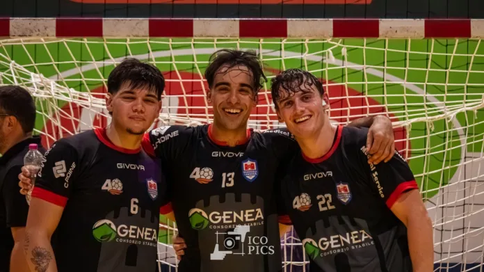 Tre giocatori della squadra Genea Lanzara abbracciati davanti alla porta di pallamano.