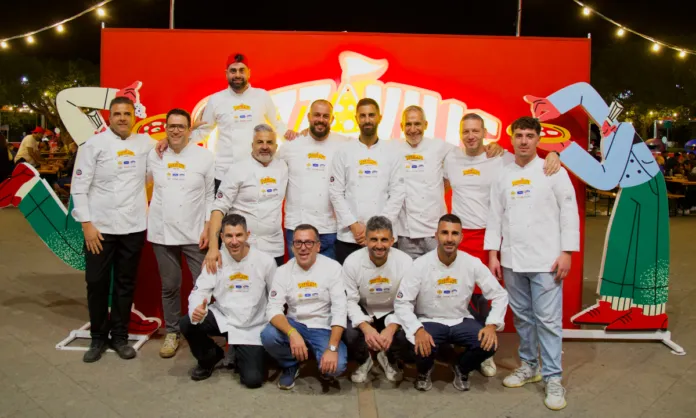 Immagine di un evento all'aperto di sera con molti partecipanti e luci colorate, rappresentativo della prima edizione di Pizzaville a Siderno.