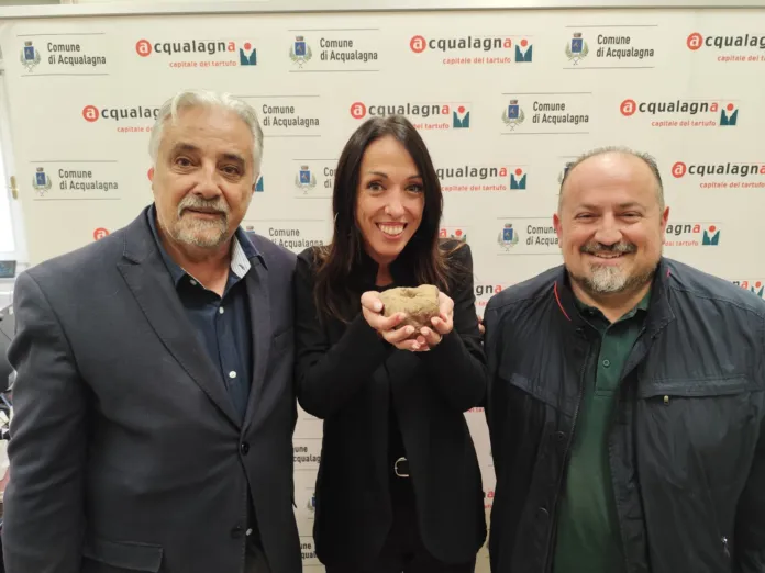 Immagine di archivio dell'apertura della fiera con un tartufo e persone sorridenti.