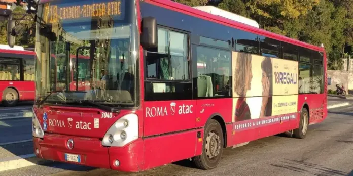 Autobus rosso con la scritta «ROMA ATAC» fermo su una strada.