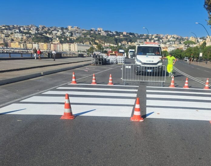 Segnaletica orizzontale ritinteggiata con coni di sicurezza su via Caracciolo vicino al lungomare.