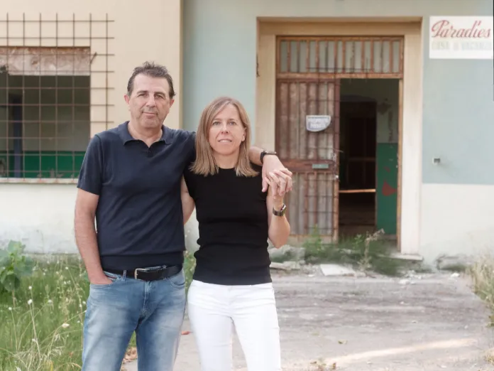 Due persone posano davanti all’ingresso dell’ex Colonia Paradies.