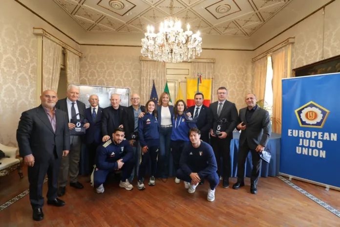 Un gruppo di persone posa in una sala accanto a uno striscione blu con la scritta European Judo Union.