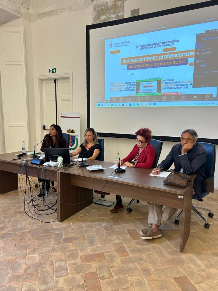 Confronto su riconoscimento professionale mediatori interculturali a Villa Altieri, tavolo con quattro relatori e diapositiva proiettata.