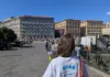 Napoli presenta una guida multilingue per studenti Erasmus e giovani stranieri Persona vista di spalle in una piazza, con una maglietta recante la scritta CiAc e una borsa a tracolla.