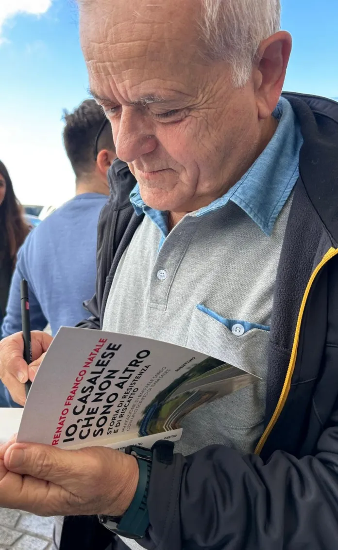 Un uomo con una giacca scura guarda un volume con il titolo “Io, casalese che non sono altro”.
