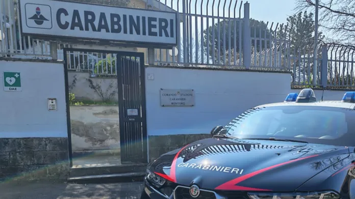 Un’auto dei Carabinieri è parcheggiata davanti a un cancello con l’insegna «Carabinieri».