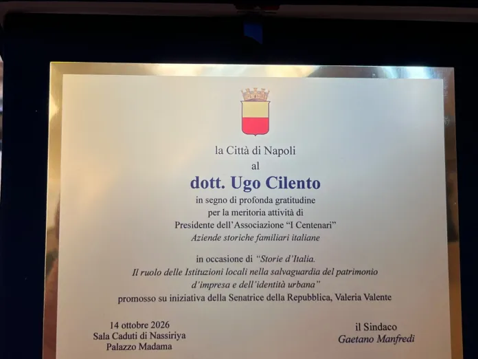 Una targa con lo stemma e la dicitura «la Città di Napoli al dott. Ugo Cilento», esposta in una cornice illuminata.