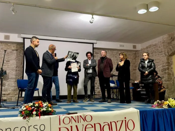 Persone sul palco davanti a un tavolo con la scritta «Concorso Tonino Di Venanzio».