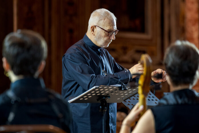 Antonio Florio dirige un'orchestra, vista di profilo durante una esibizione.