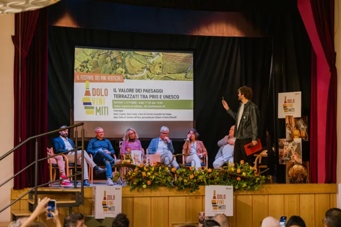 Convegno con panel di relatori su palco e pubblico durante la quarta edizione di DoloViniMiti.