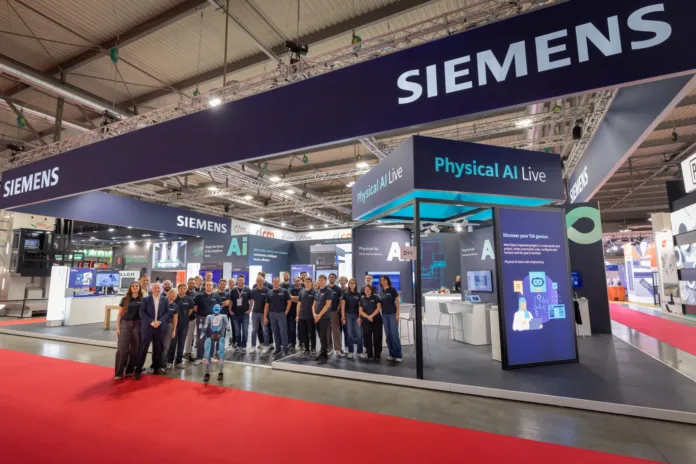 Stand Siemens con banner e personale a una fiera industriale, con esposizione di tecnologie di automazione e robotica.