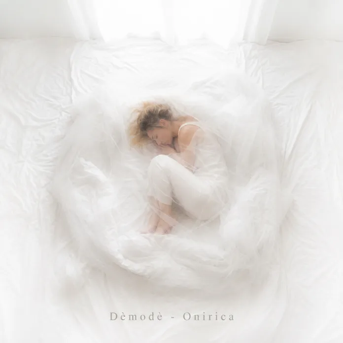 Fotografia di archivio di una donna sdraiata su un letto coperto di bianco, in un ambiente luminoso.